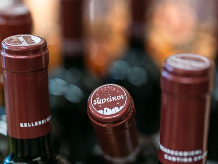 © IDM Südtirol/Hannes Unterhauser Seal of the Alto Adige wine PDO between two bottles. | © IDM Südtirol/Hannes Unterhauser